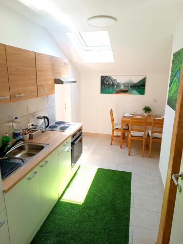 a kitchen with a sink and a table at Apartments Romantic and Family Room Zemlinski in Payerbach
