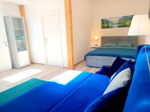 a bedroom with a blue bed and a window at Apartments Romantic and Family Room Zemlinski in Payerbach
