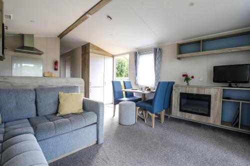 a living room with a couch and a table at Tehidy Holiday Park in Illogan