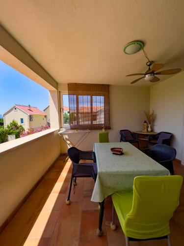 a dining room with a table and chairs and a window at Apartments Panda in Bol
