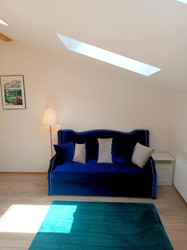 a blue couch in a living room with a skylight at Apartments Romantic and Family Room Zemlinski in Payerbach