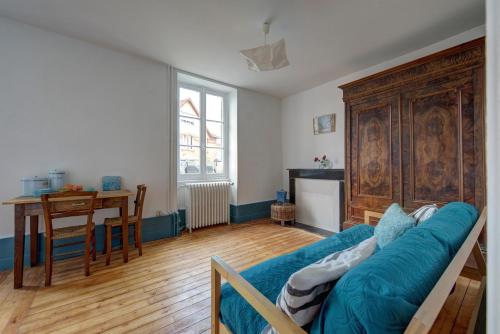 un salon avec un canapé bleu et une table dans l'établissement Villa des fleurs, à Saint-Honoré-les-Bains