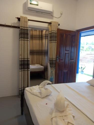 a bedroom with a bed with towels on it at Lilly Pilly Villa Arugambay in Arugam Bay