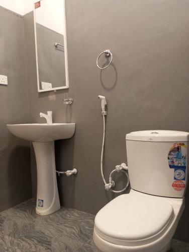 a bathroom with a toilet and a sink at Lilly Pilly Villa Arugambay in Arugam Bay
