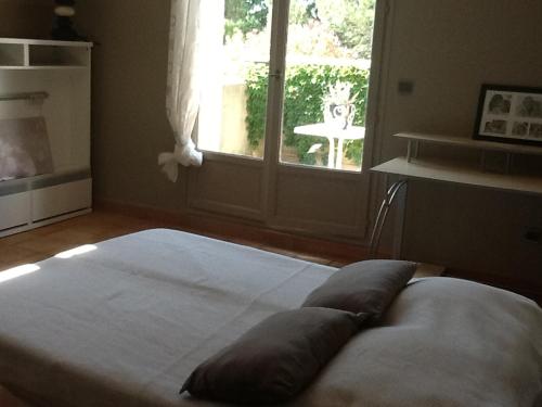 un grand lit dans une chambre avec une fenêtre dans l'établissement Villa, à Sorgues
