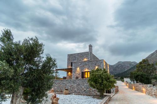 a stone house with lights on the side of it at Armenopetra View Gerolimenas in Gerolimenas