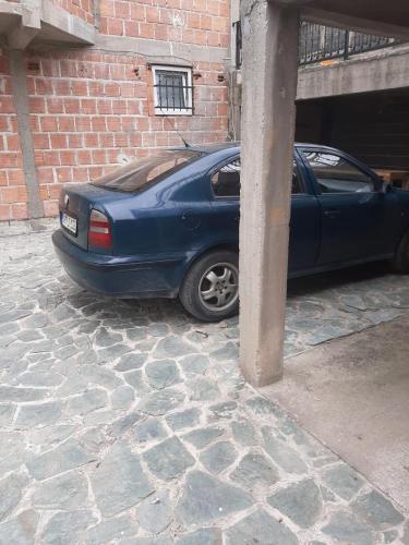 a blue car parked next to a brick building at Medina in Sarajevo
