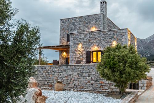 a stone house with lights on the facade at Armenopetra View Gerolimenas in Gerolimenas