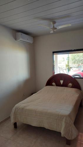 a bedroom with a bed in a room with a window at Casa Com Piscina. Prox. Mar e Lagoa Ideal Família in Marataizes