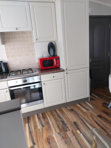 a kitchen with white cabinets and a red microwave at STAG LODGE in Richmond