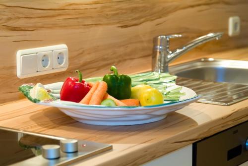 a bowl of vegetables sitting on a counter next to a sink at Das Bäckergut am Haldensee in Haldensee