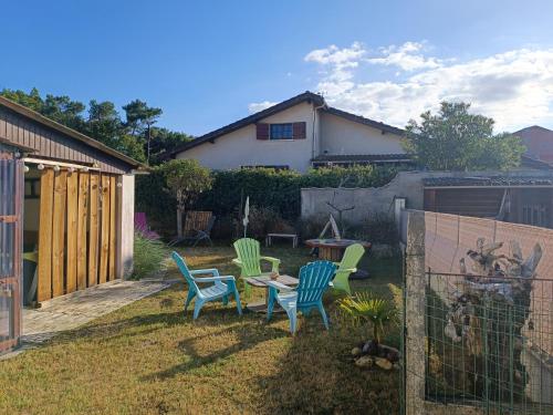 un patio con sillas, una mesa y una valla en Villa Ilanga, en Soulac-sur-Mer
