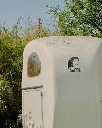 a small white trailer with a logo on it at Les écuries du Nevez in Plonéour-Lanvern