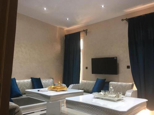 a living room with two tables and a couch at Ghazalle oasis Hotel GB in El Biar