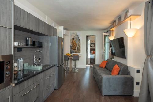 un salon avec un canapé et une télévision dans l'établissement Marais, Rue Beaubourg - 6 places, à Paris