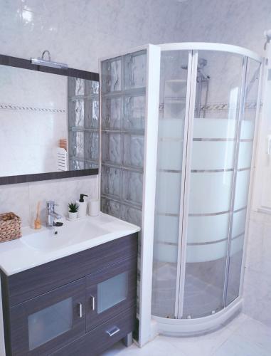 a bathroom with a shower and a white sink at La Casita de Suances 1- Jardín y Parking, Ideal Familias y Mascotas in Suances