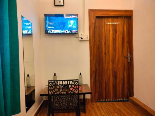a room with a wooden door and a table and a chair at Kishan Home Stay in Mathura
