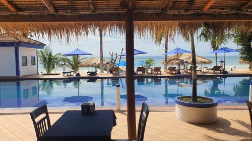 a swimming pool with a table and chairs and umbrellas at Amor Resort Koh Rong in Koh Rong Island