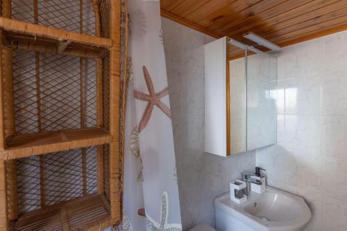 a bathroom with a sink and a mirror at Ionian Cape seaside apartment in Vráchos