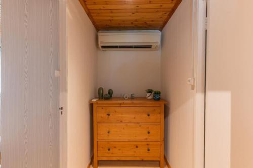 a bedroom with a wooden dresser and a ceiling at Ionian Cape seaside apartment in Vráchos
