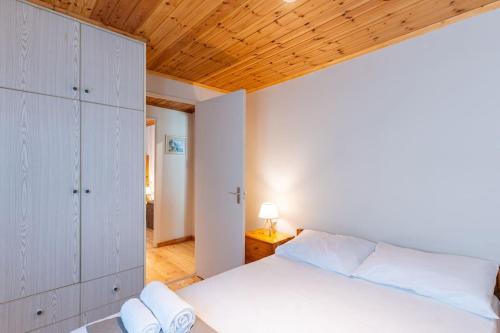 a bedroom with a white bed and a wooden ceiling at Ionian Cape seaside apartment in Vráchos