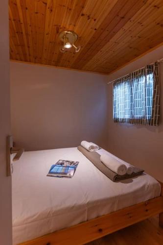 a bed in a bedroom with a wooden ceiling at Ionian Cape seaside apartment in Vráchos