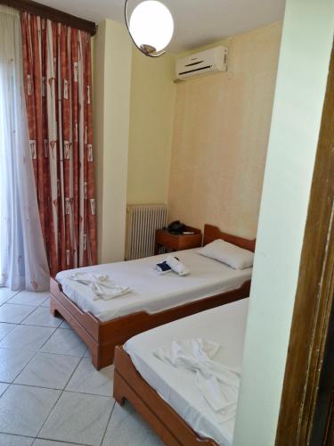 a room with two beds and a window at Hotel Athina in Asprovalta