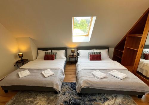 two beds in a small room with a window at Apartamenty Nyskie in Zgorzelec