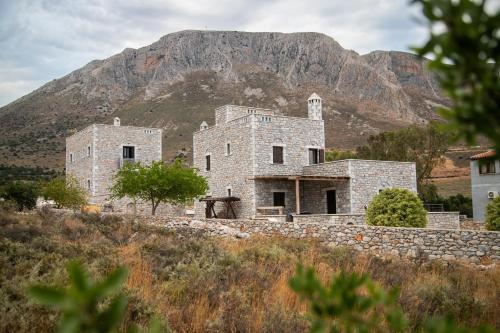 a stone building with a mountain in the background at Armenopetra View Gerolimenas in Gerolimenas