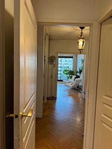 un couloir avec une porte s'ouvrant sur un salon dans l'établissement Paris Eiffel, à Paris