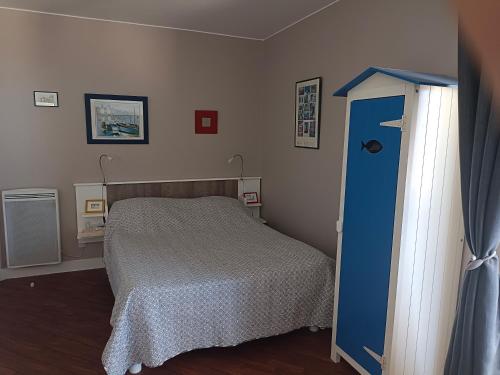 - une petite chambre avec un lit et une porte bleue dans l'établissement FACE MER PORNICHET BAIE DE LA BAULE GRAND STUDIO, à Pornichet