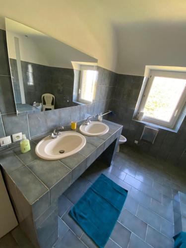 une salle de bain avec deux lavabos et un grand miroir dans l'établissement Danydan- Brignogan-Plages - Maison de charme Bretonne en Granit sur la côte des légendes, à La Terre du Pont