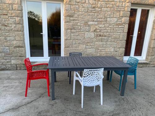 une table noire entourée de quatre chaises dans l'établissement Danydan- Brignogan-Plages - Maison de charme Bretonne en Granit sur la côte des légendes, à La Terre du Pont