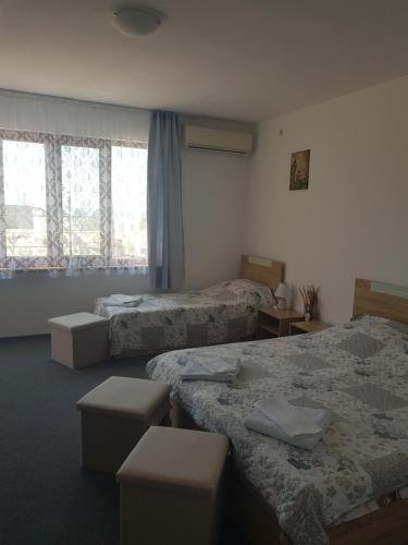 a hotel room with two beds and windows at Guest Rooms Radost in Balchik