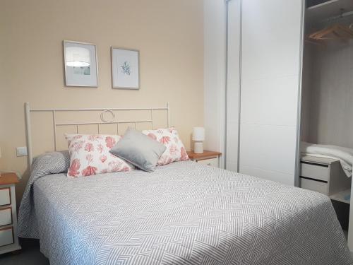 a bedroom with a bed with pink and grey pillows at Vistahermosa-El ancla in El Puerto de Santa María