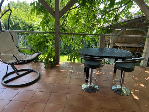 a patio with a table and two stools at Pod kasztanem in Olsztynek