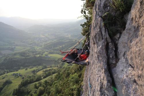 deux personnes dans un hamac suspendu à une falaise dans l'établissement Pyrénées nuit suspendue, à Montory