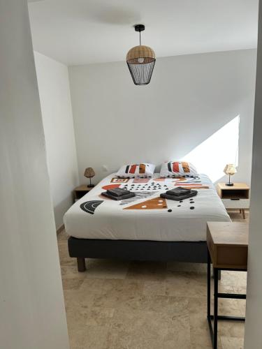 une chambre avec un lit et un mur blanc dans l'établissement Bord de mer, à Benerville-sur-Mer