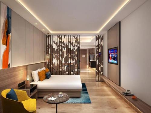 a room with a bed and a couch and a tv at Regenta Place Amritsar by Royal Orchid Hotels Limited in Amritsar