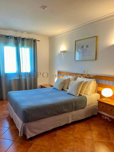 a bedroom with a large bed with a blue blanket at Grupo Morgado - Quinta do Morgado - Morgado Privilege in Tavira