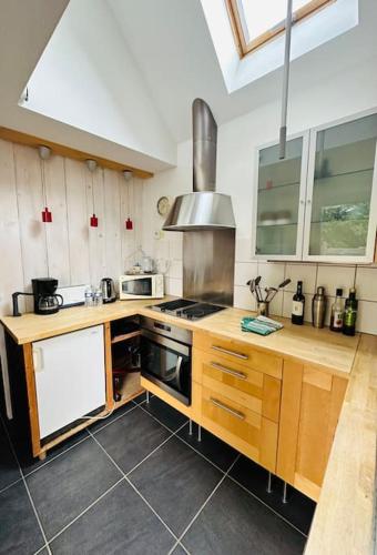 une cuisine avec des armoires en bois et un four à plaques de cuisson dans l'établissement Studio à Port Manec'h - Plage et port à pied, à Névez