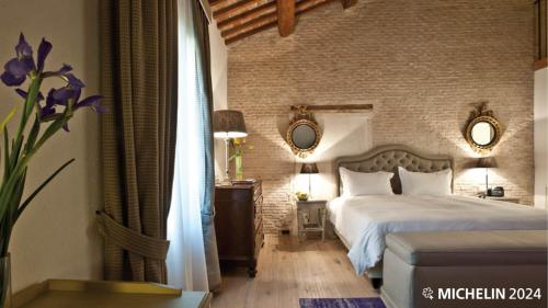 a bedroom with a bed and a brick wall at La Barchessa di Villa Pisani in Lonigo