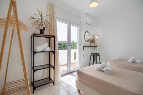 a white room with two beds and a window at Babilia central appartment suites Limenas Hersonisou in Hersonissos