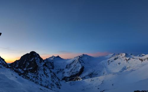 a snow covered mountain range with the sunset in the background at NEW ENTRY - Nuova villa nel verde in Mezzana