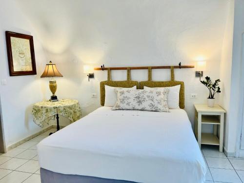 a bedroom with a large white bed and a table at Le Petit Greek in Fira