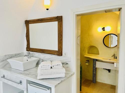 a bathroom with a sink and a mirror at Le Petit Greek in Fira