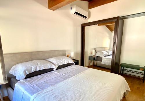 a bedroom with a large bed and a mirror at Da Mario Superior Apartment in Malcesine