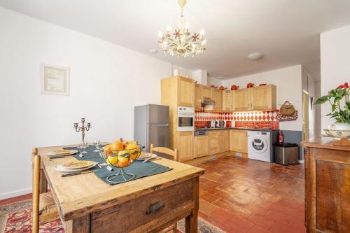 une cuisine avec une table avec un bol de fruits dessus dans l'établissement La Maison des Remparts, à Saint-Jean-de-Barrou