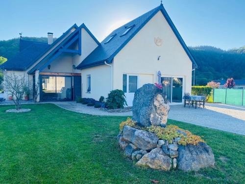 une maison blanche avec un rocher dans la cour dans l'établissement Chez Pat et Olive - gîte 4 personnes- Bagnères de Bigorre, à Pouzac