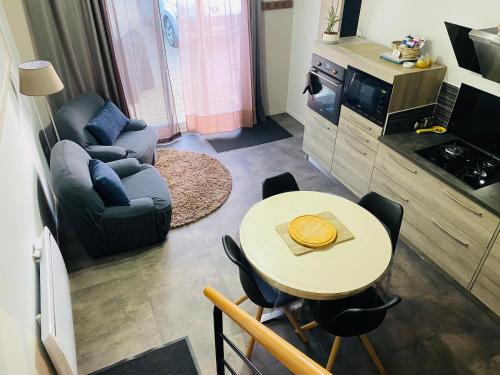 un petit salon avec une table et un canapé dans l'établissement Chez Pat et Olive - gîte 4 personnes- Bagnères de Bigorre, à Pouzac